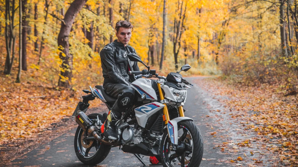Jonge man op een motorfiets genietend van een schilderachtige rit in de herfst in Vilnius, Litouwen.