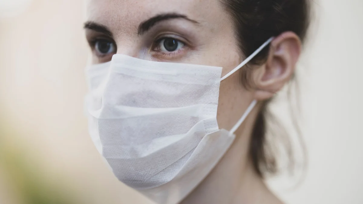 Close-up van een vrouw die een beschermend gezichtsmasker draagt voor gezondheidsveiligheid.