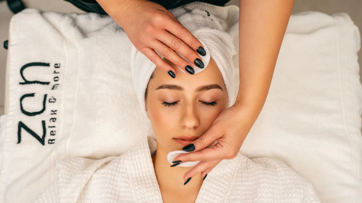 Een vrouw die een rustgevende gezichtsbehandeling ontvangt in een Zen-spa voor ontspanning en huidverzorging.