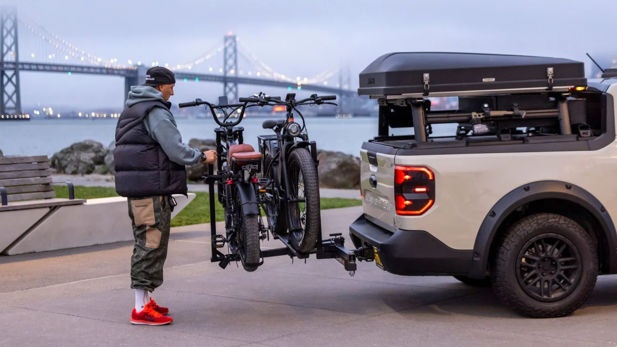 Een man maakt een elektrische fiets vast op een pick-up truck in de buurt van de Bay Bridge in San Francisco.