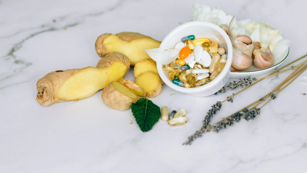 Een flat lay met gember, knoflook en diverse kruiden supplementen op een marmeren oppervlak.