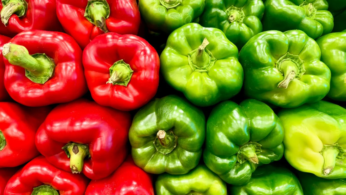 Een kleurrijke presentatie van verse rode en groene paprika's, ideaal om mee te koken of als tussendoortje.