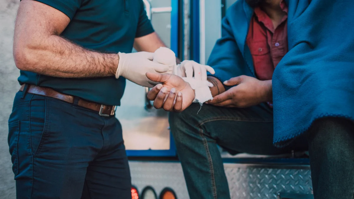 Paramedicus biedt eerste hulp aan een gewonde persoon bij een ambulance.