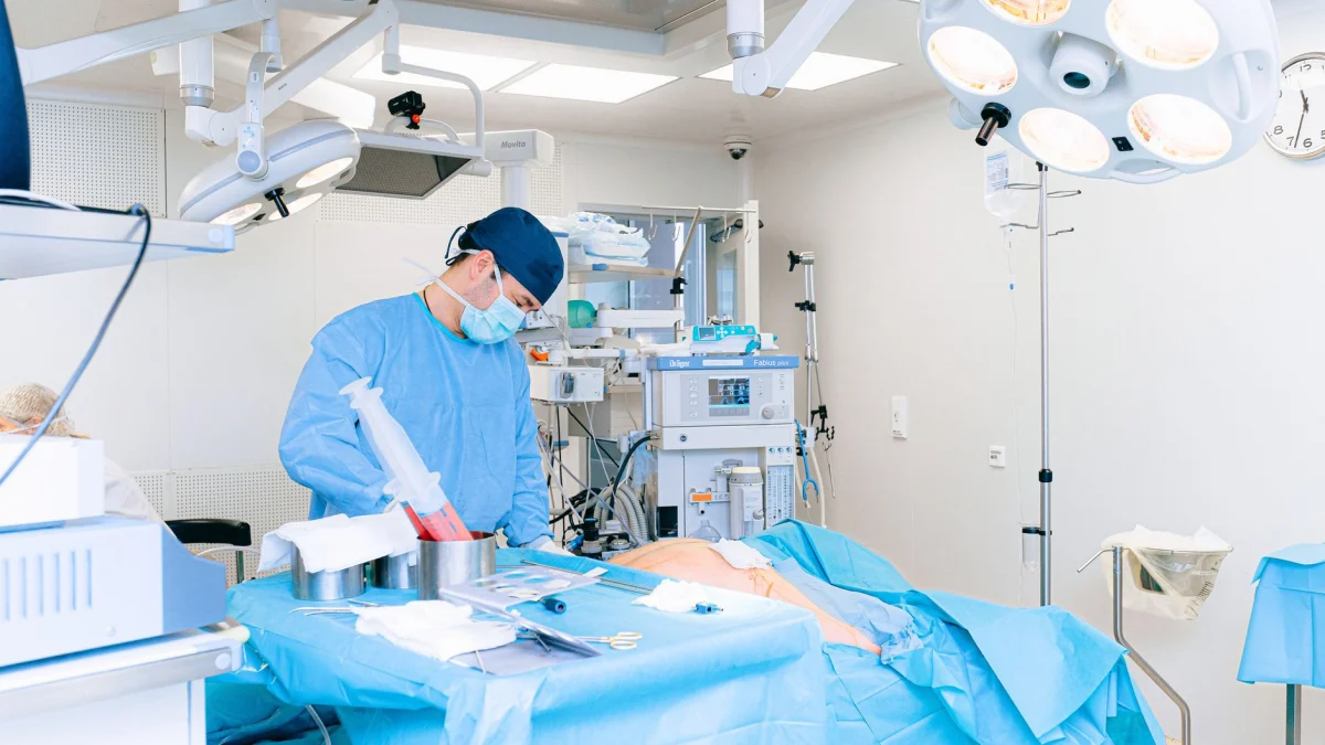 Ervaren chirurg die een procedure uitvoert in een goed uitgeruste operatiekamer.