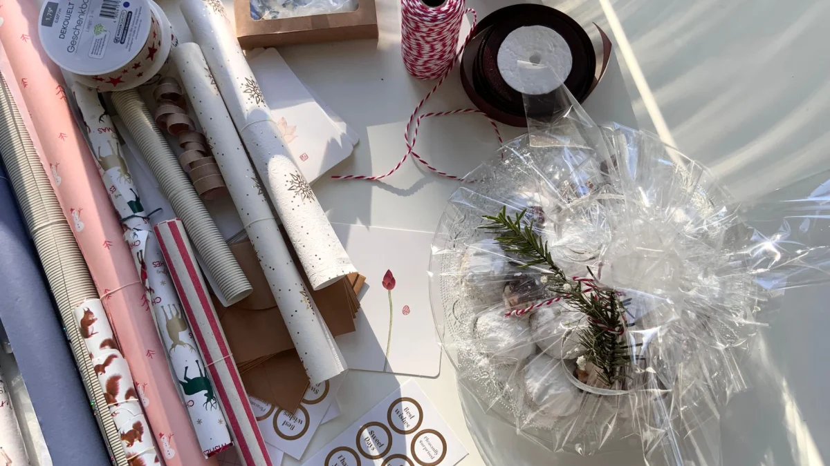 Bovenaanzicht van diverse cadeau-verpakkingsmaterialen, waaronder papier, touw, lint en decoratie.
