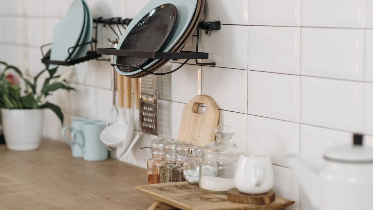 Georganiseerde keuken met keukengerei, specerijen en een witte tegels muur. Ideaal voor kookthema's.