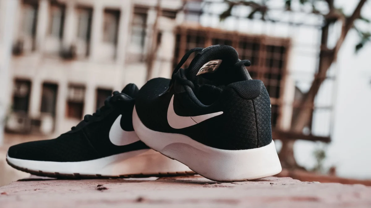 Close-up van zwarte sneakers op het stadsplaveisel in New Delhi, India.