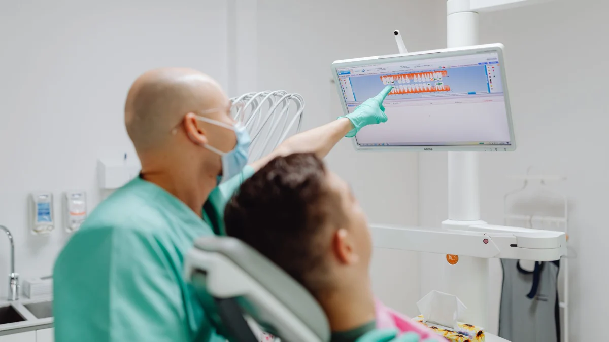 Tandarts onderzoekt patiënt met tandheelkundige beeldsoftware in moderne kliniek.