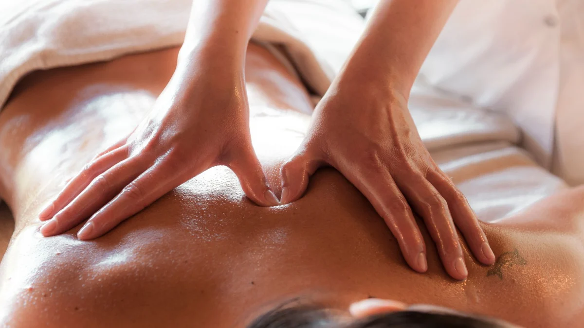 Close-up van een ontspannende massagesessie, met de focus op rugtherapie in een spa.