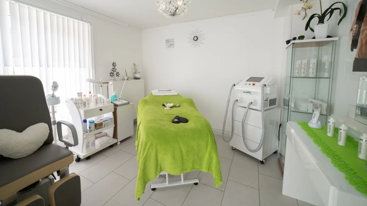 Heldere en gezellige kliniekruimte met een comfortabel behandelingsbed en moderne apparatuur.