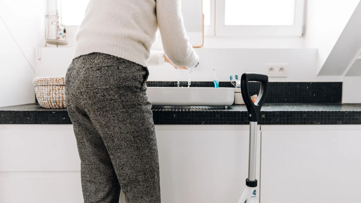 Een senior gebruikt een rollator in een moderne badkamer met strakke designelementen.