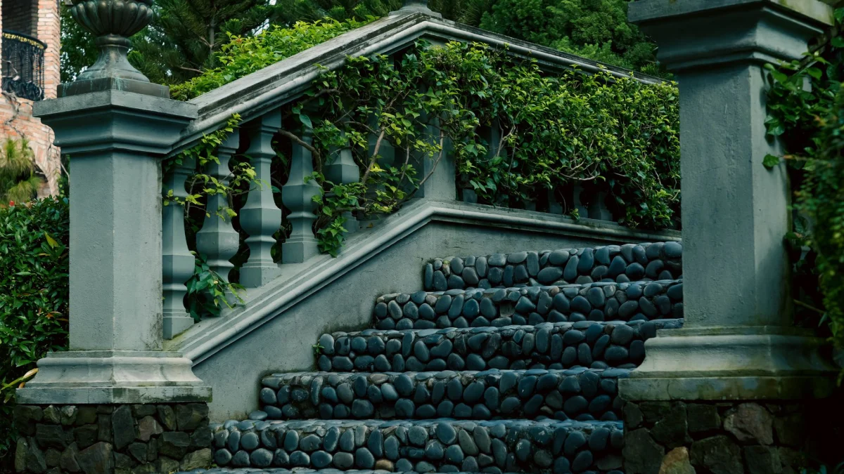 Een serene stenen trap versierd met weelderig groene klimop in een klassieke tuinomgeving.