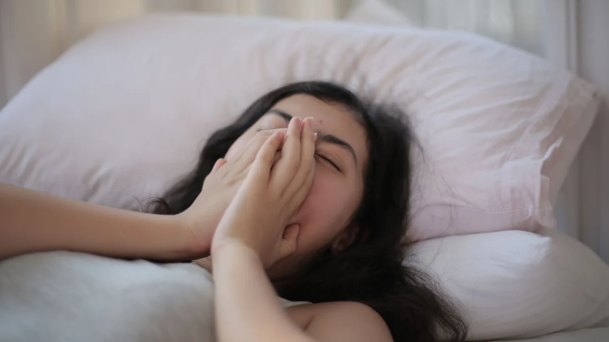 Een serene scène van een vrouw die in bed rust, die ontspanning en comfort uitstraalt.