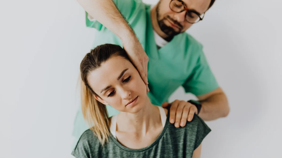 Professionele chiropractor behandelt de nekpijn van een vrouw met therapeutische technieken.